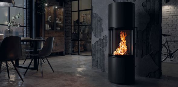 Schwarzer Kamin steht rechts neben Essbereich in dunklem Ambiente mit schwarzer Einrichtung