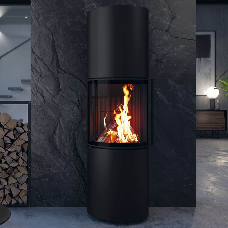 Schwarzer Kamin mit brennendem Feuer vor schwarzer Steinwand.